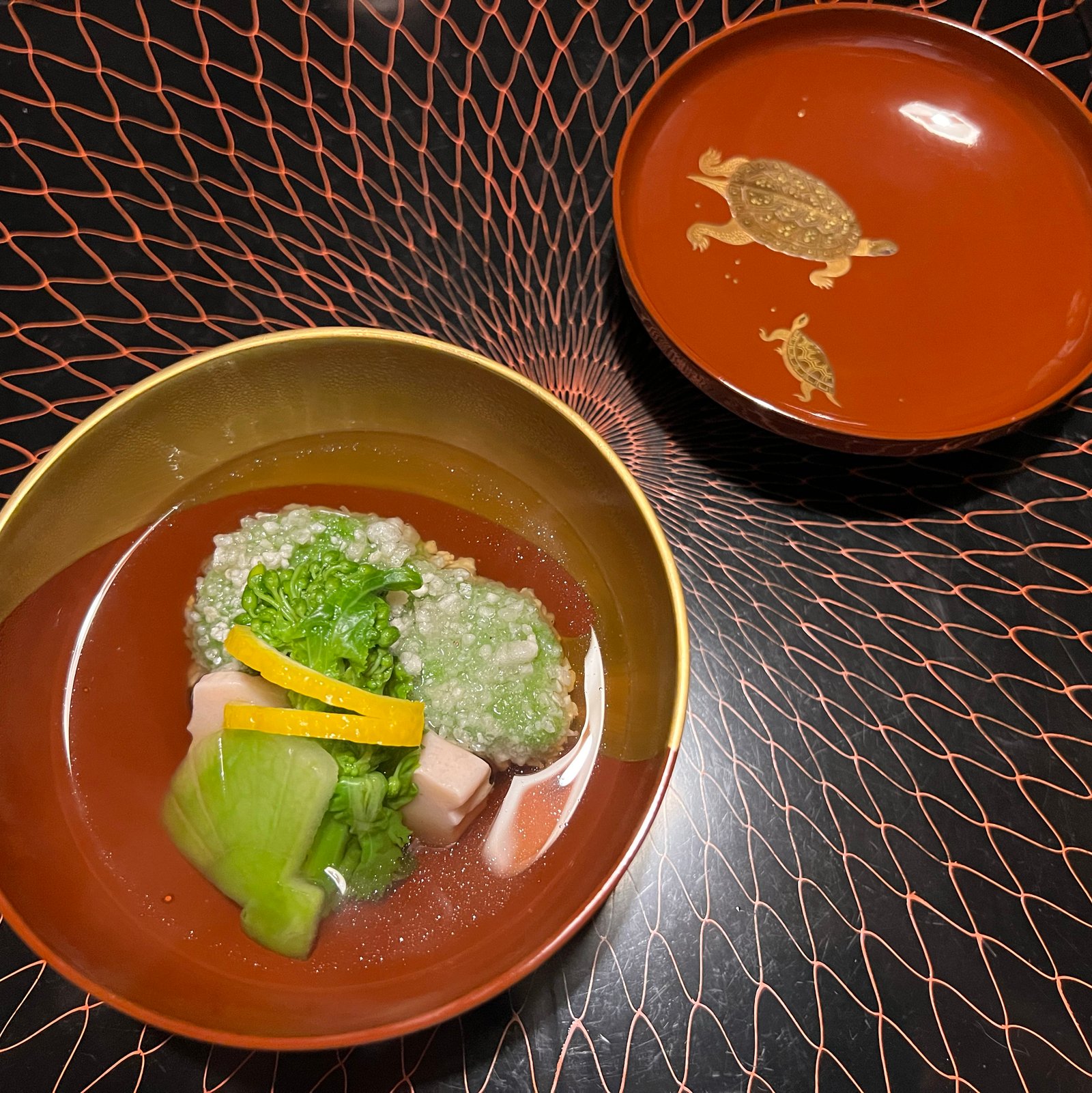 Caldo con verduras en laca roja